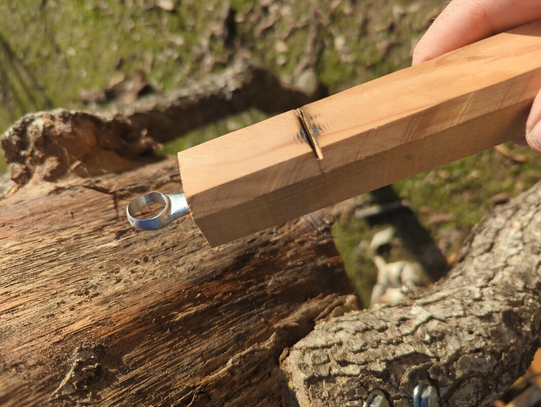 the end of the 13mm wrench sticking out of a wooden rod