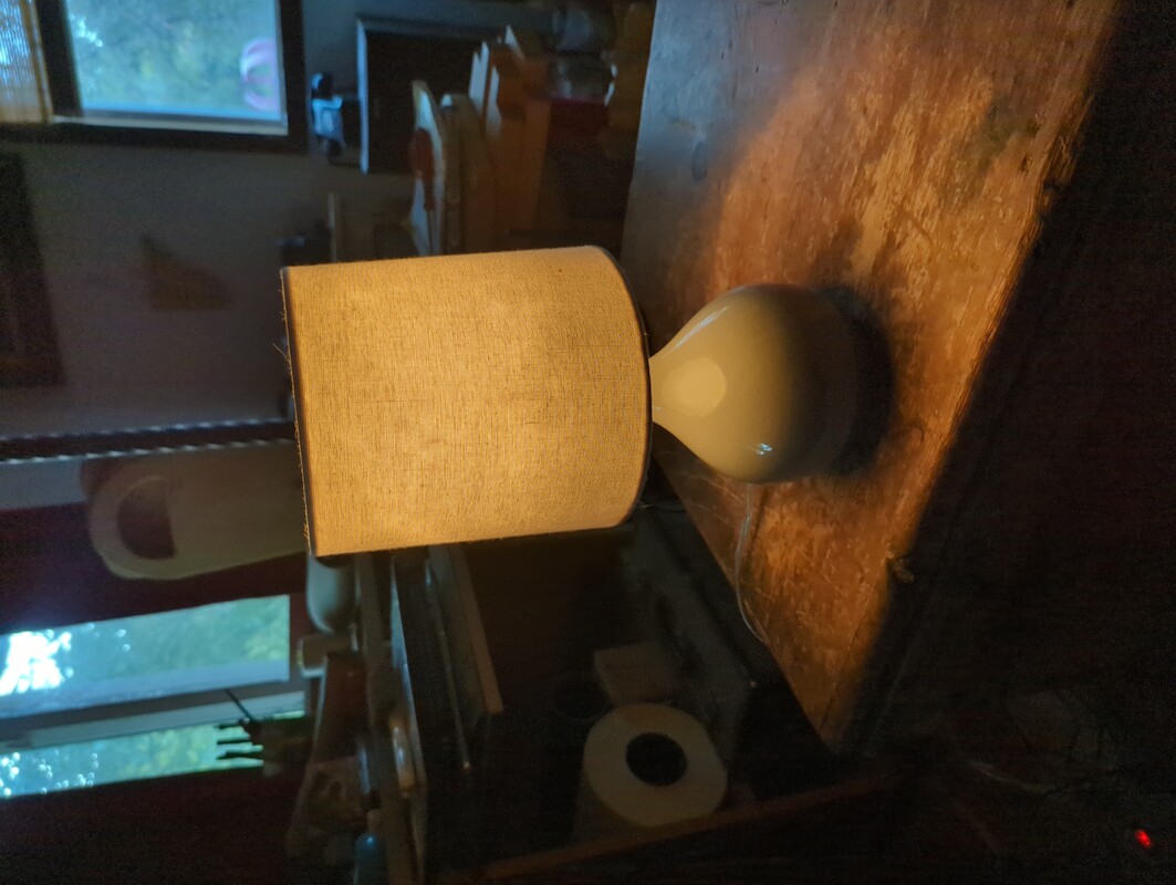 a small lamp on a table in a cluttered room