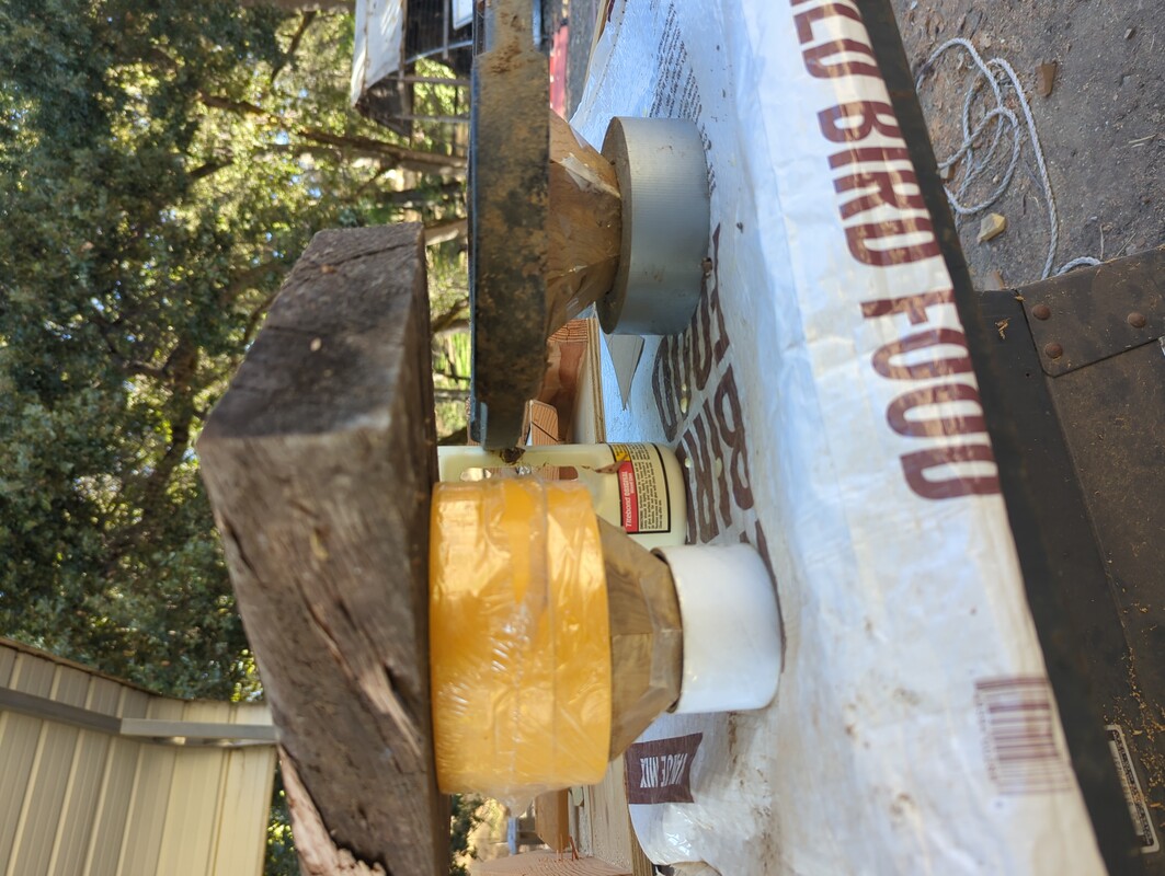 pyramids of wood, upside down, with the points in the center of tape rolls, and weights pressing down from the top