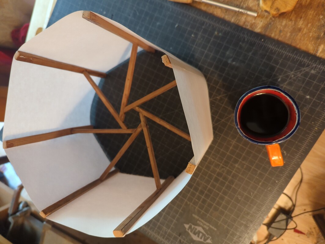 7 sided lamp shade frame, with paper glued to the vertical pieces of wood