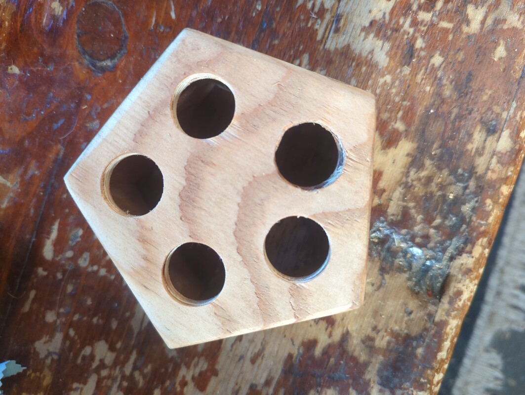 A sanded pentagon, with 5 holes drilled.